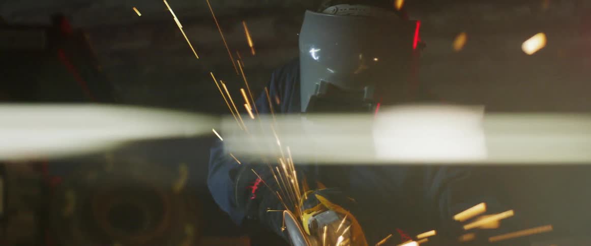 A man in a mask welds a project