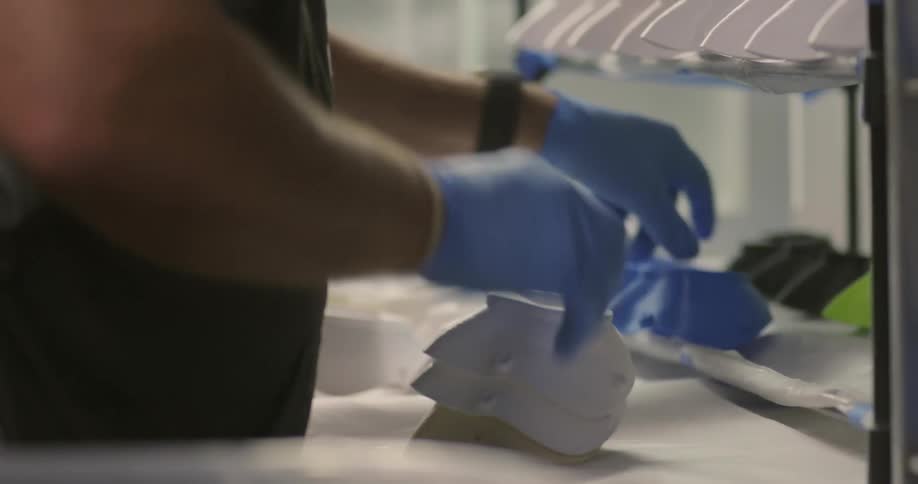 A man in a shop lines up parts on a shelf