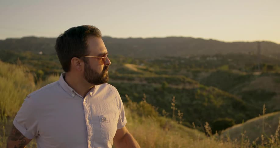 A man walks outside and looks across the landscape