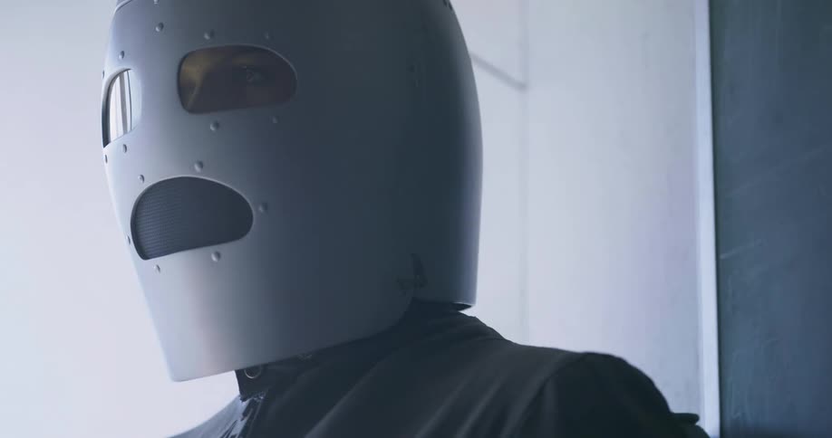A person standing with a metal mask