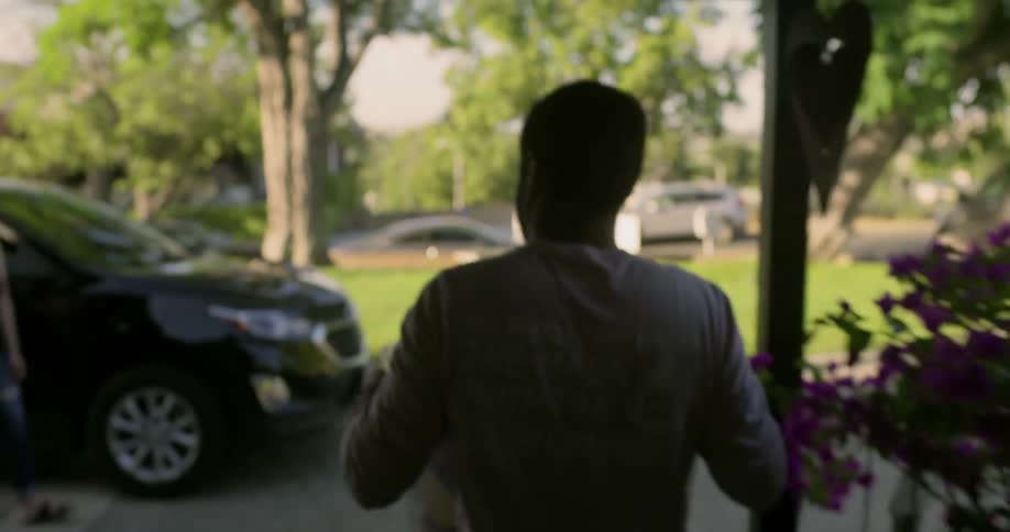 A man carries a bin out of his house and hands it to a woman