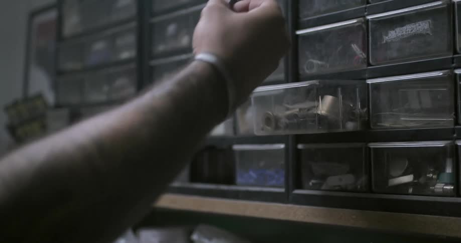 A person takes some bolts from a storage shelf