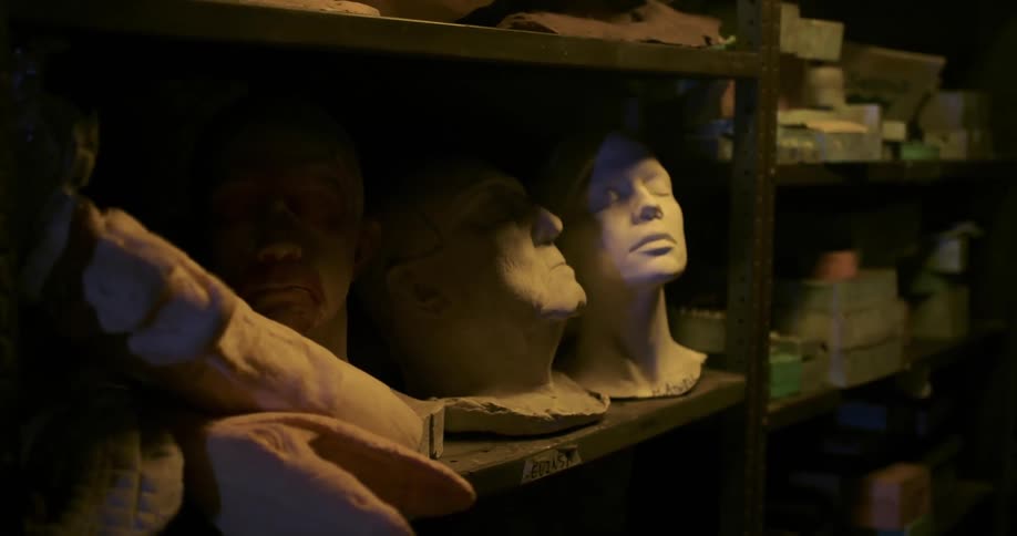 Props and sculptures sit on a shelf