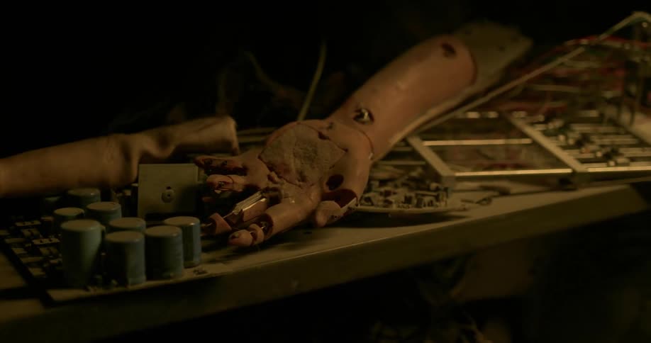 Broken prosthetic arm abandoned in a shelf on a dimly lit room