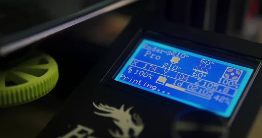 A 3d printer display flashes data as a metal plate moves