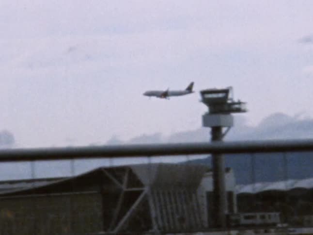 An airplane flying in the sky over an airport