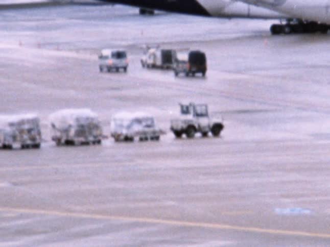 A vehicle hauls cargo over to airplanes on a tarmac