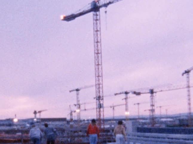 A group of teens skateboard through a construction site