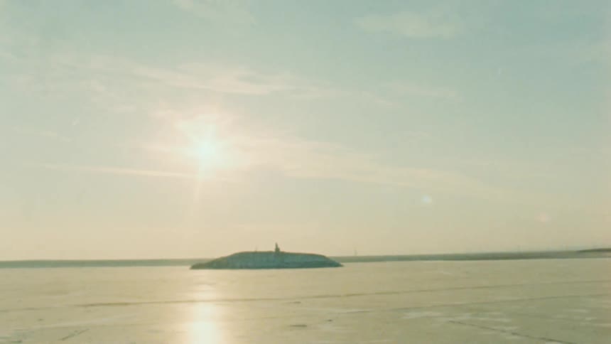 A small island sits in the water ahead