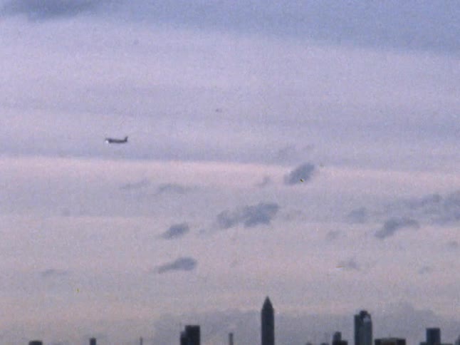 A plane flying through the sky over a city