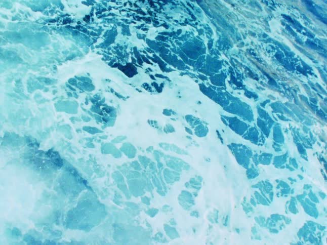 Ocean waves crest and crash into foam