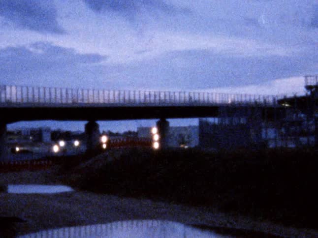 View of a bridge over a dry river bed at dusk