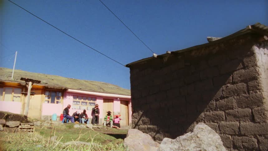 A group of people gather around a house