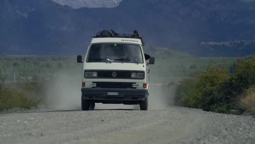 A car is driving down a dirt road