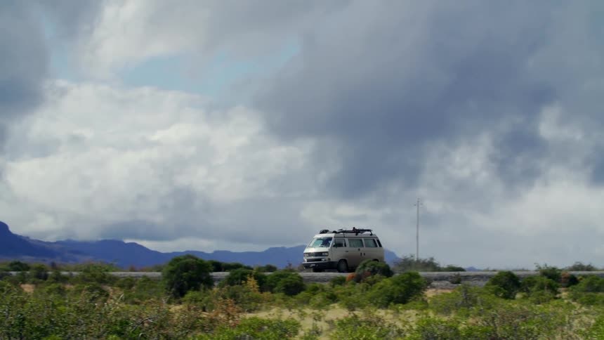 A van drives down a road through a rural area