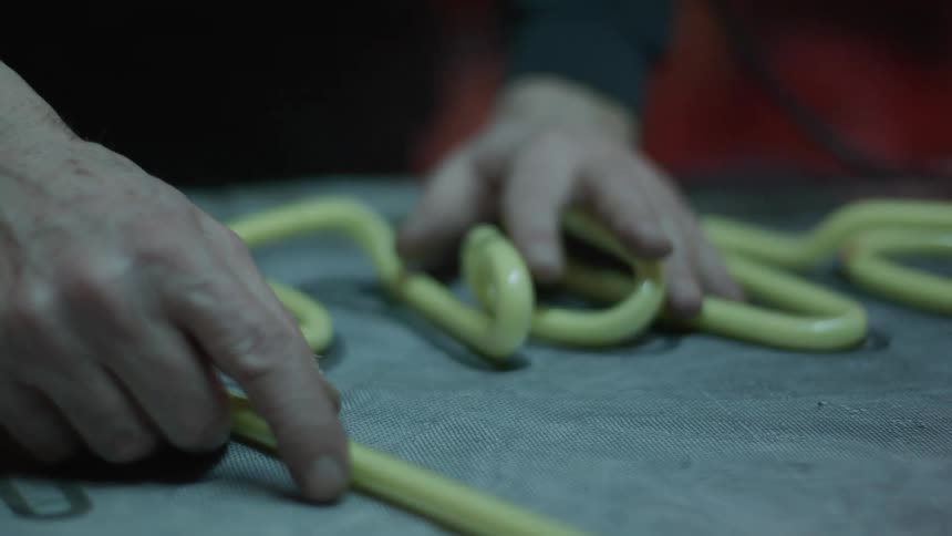 Man works on a neon sign in a workshop