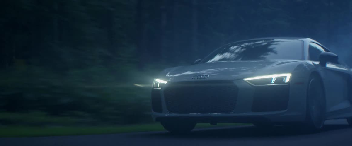 An audi travels on a road at night