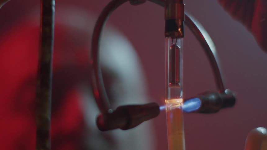 Laser cuts the glass tube while a man watches
