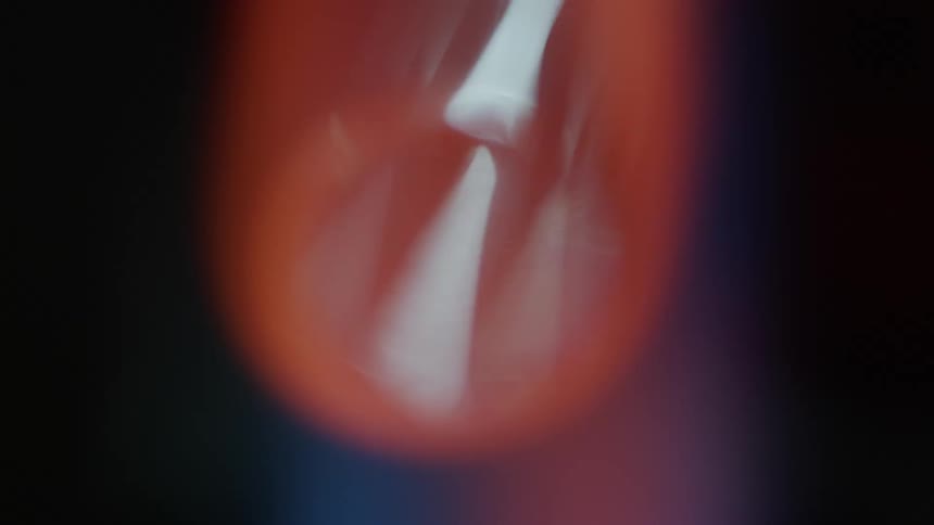 A flame burns with orange and blue colors