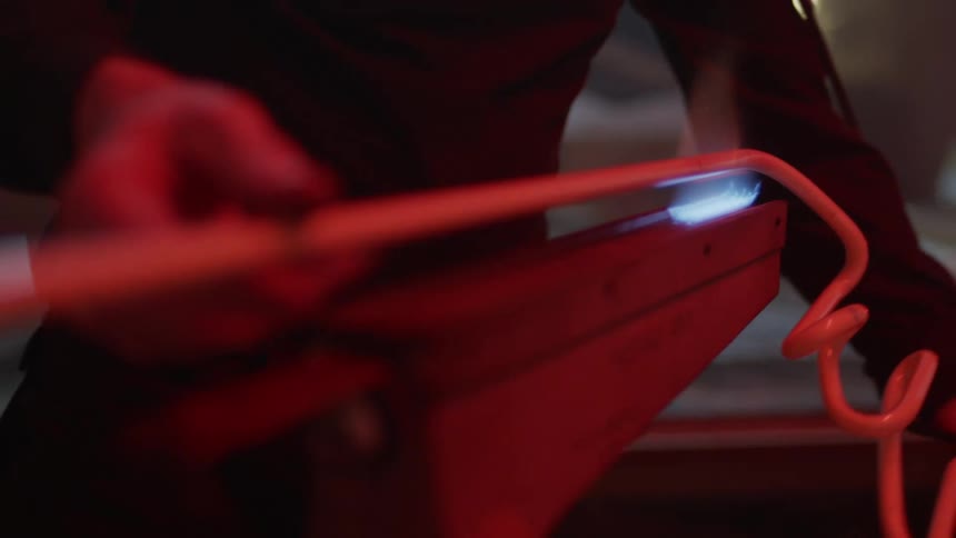 A man heats up a metal rod with fire