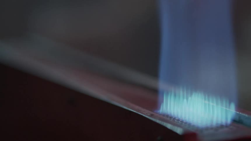 A white man uses a lighter to ignite a burner