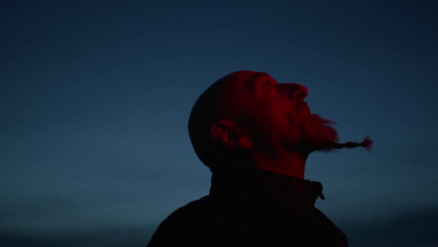 A man is standing outdoors at night
