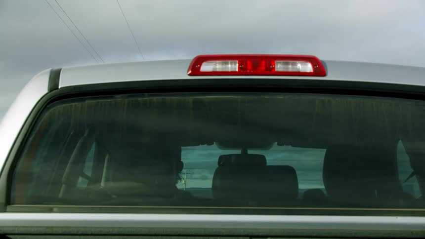 Tight shot of a pickup truck driving down a rural dirt road on the way back to the ranch after a long day