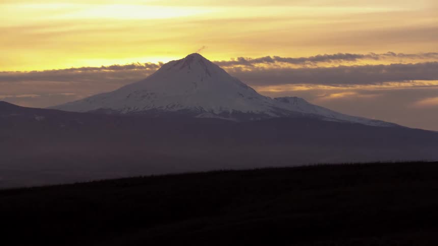 Time lapse of Mount Hood at Sunset as a passing jet stream moves clouds past the mountain rapidly