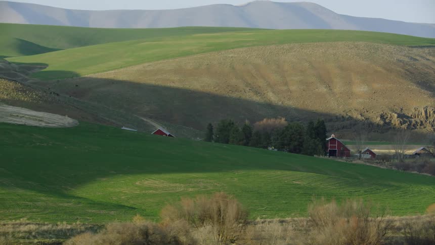 Looking out the window of the ranch pickup truck at our vast farm in the valley below with green meadow grass and rolling hills
