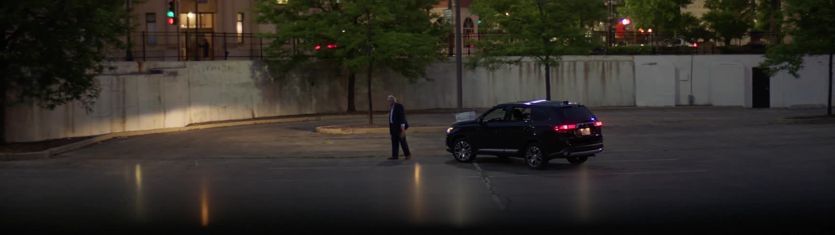 Person angrily throwing a bottle down in a parking lot at night