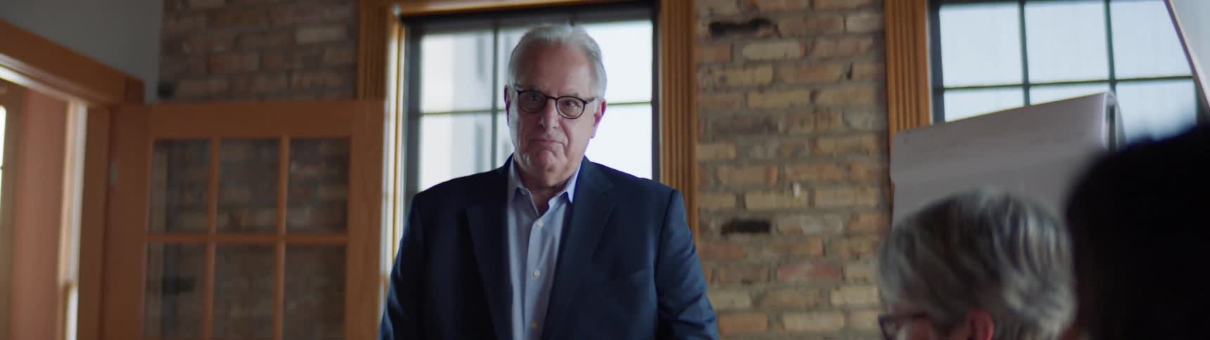 Elderly businessman conducts a business meeting with coworkers in the office