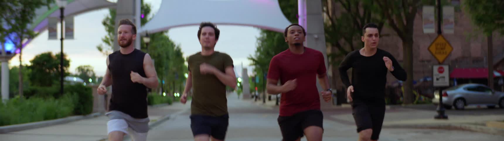 Four men run together in a town road