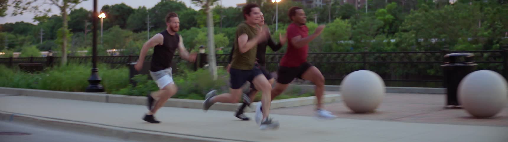 Group of men compete running on a park in a city
