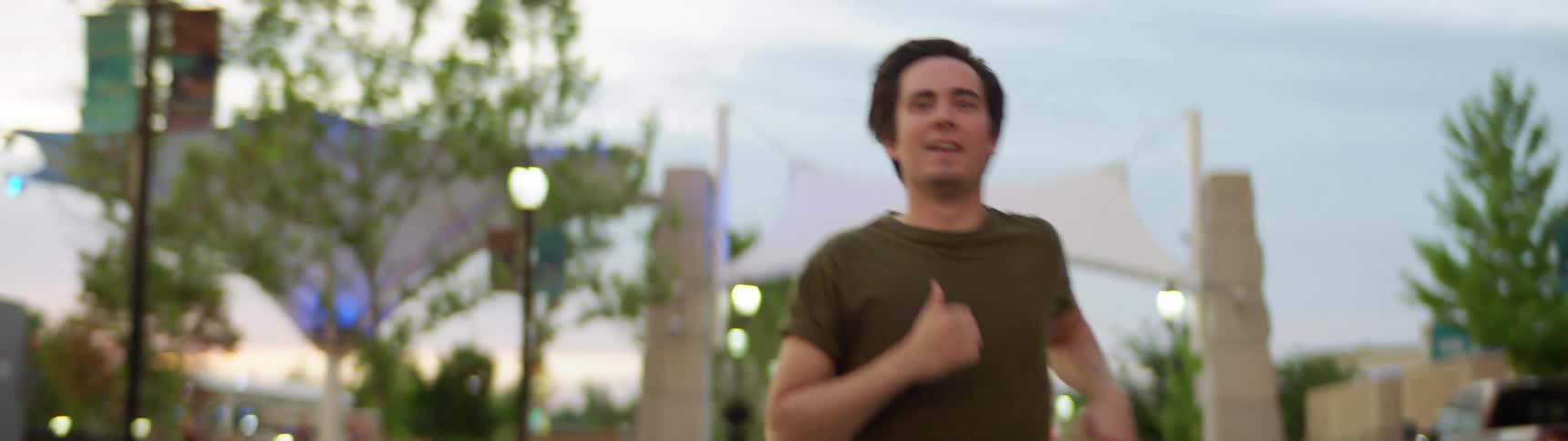 A man is jogging in a downtown city