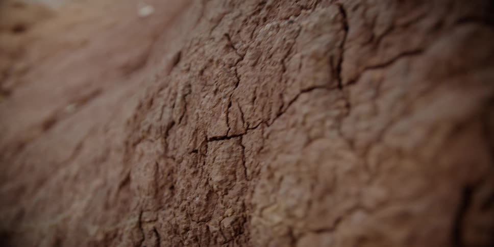 The side of a mountain has cracks in the rock