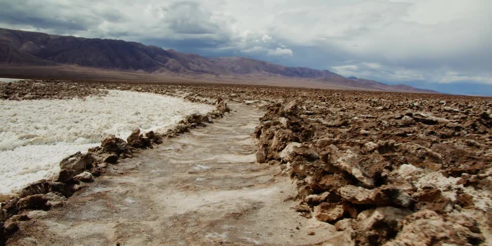 Trail winds its way through the rocky land towards the mountains