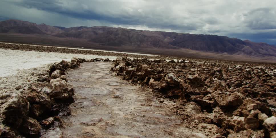 A dirt path between rocky terrain in a desert