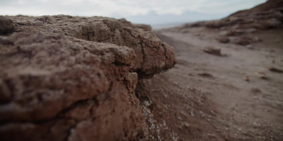 Dirt and rocks with the sky and clouds in the background