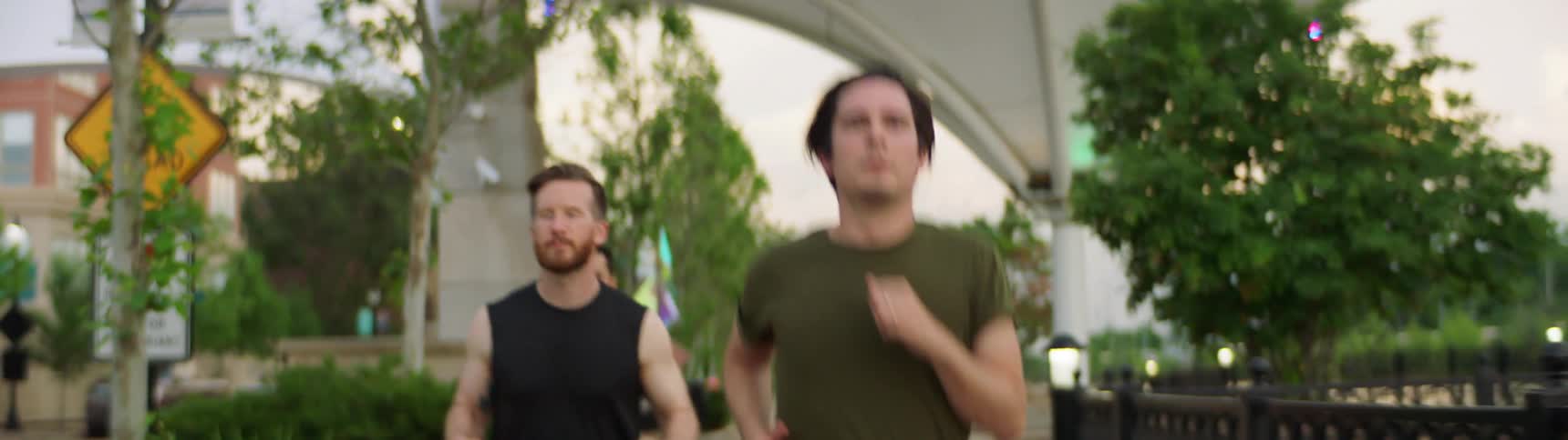 Group of men jogging on a park at sunset