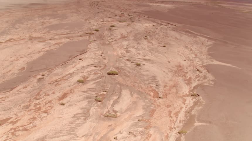 A dry river bed runs through a desert area