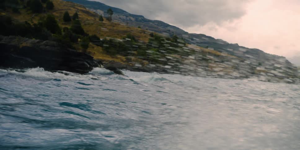Ocean waves break against the rocky coast on a cloudy day