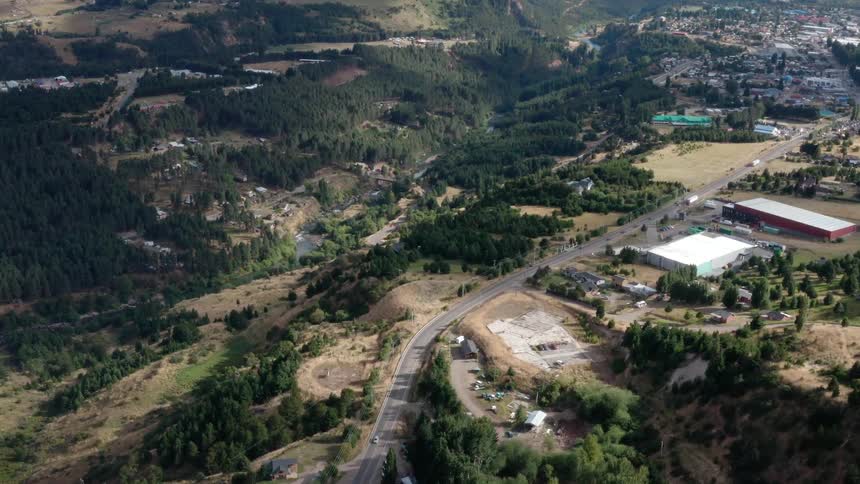 Houses dotted on a slope in the countryside gives way to a dense suburb with houses closer together