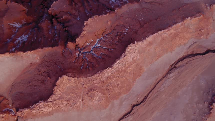 Bits of snow dot a rocky and multileveled terrain