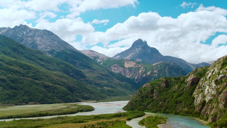 Mountains tower over a valley with a river running through it