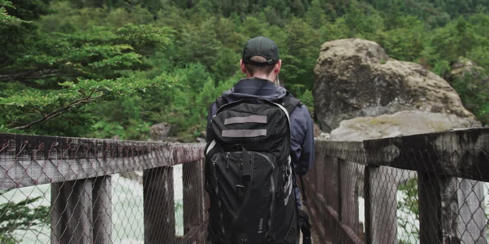 Walking across a narrow wooden bridge in the rainforest