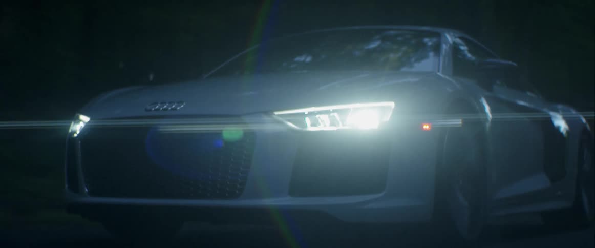 A car drives on a road in the woods