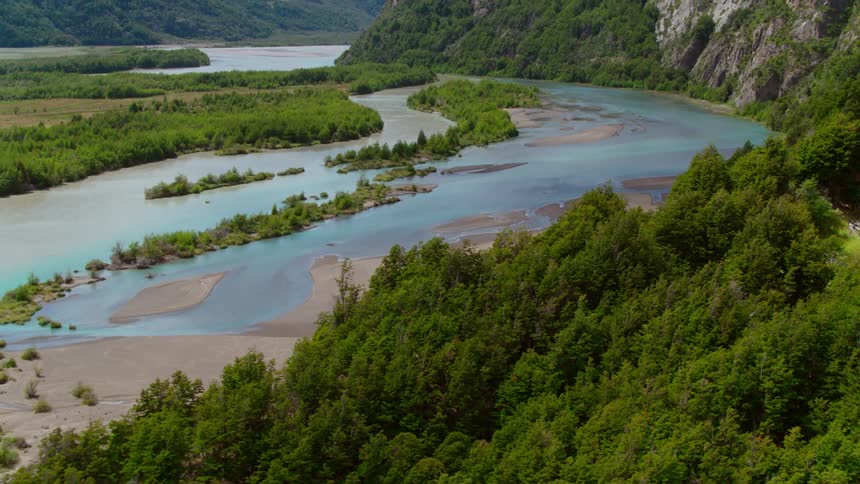 A wetland in a valley between verdant mountains on a sunny day