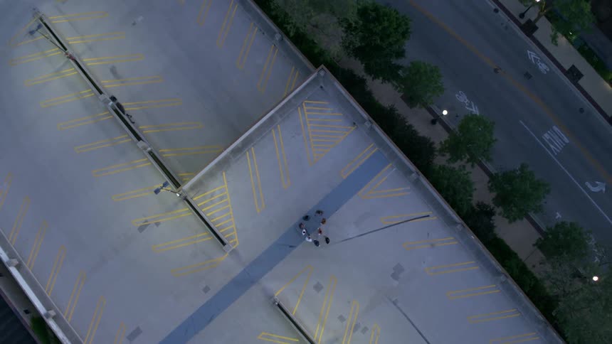 Birds eye view of nine men talking on a roof top