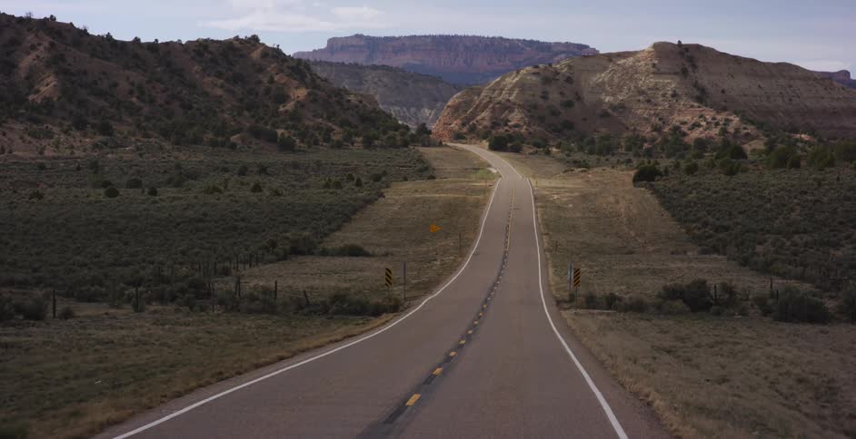 A road in the desert with mountains in the background
