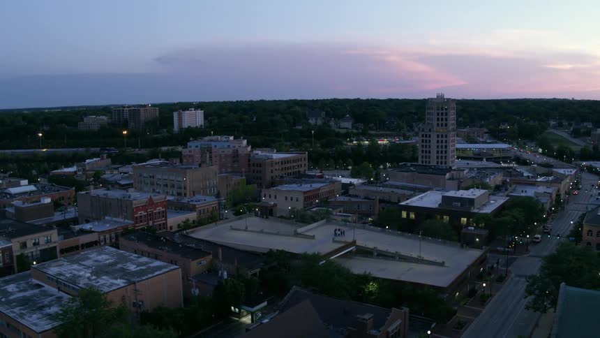 Group of people on the roof of a parking garage in the city at sunset